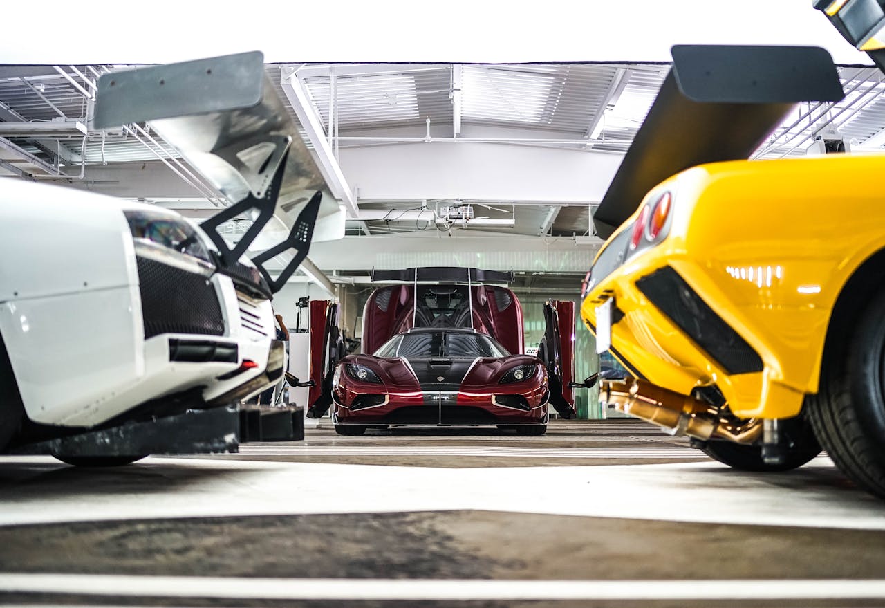 Vibrant supercars in a modern, well-lit garage showcasing sleek designs and engineering.